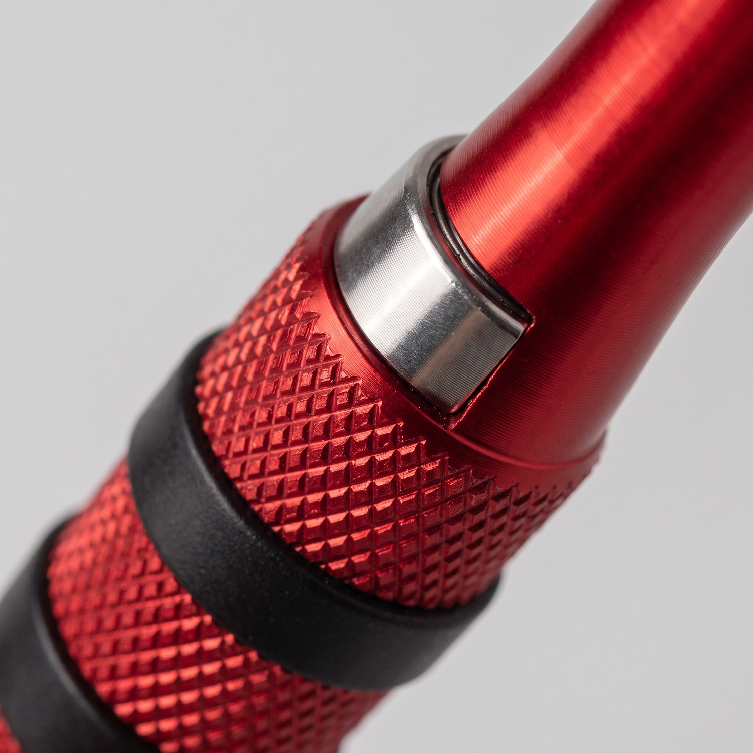 Gros plan sur la poignée aluminium rouge moletée et le roulement à billes de la corde speed rope