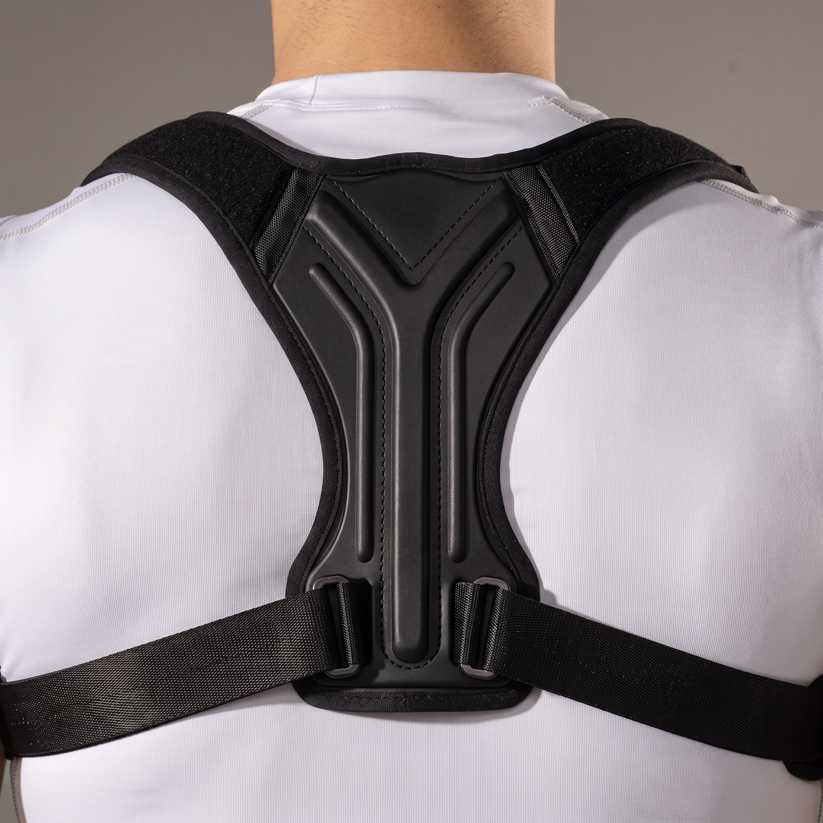 Détail de la plaque dorsale en Y et des boucles de serrage du correcteur de posture