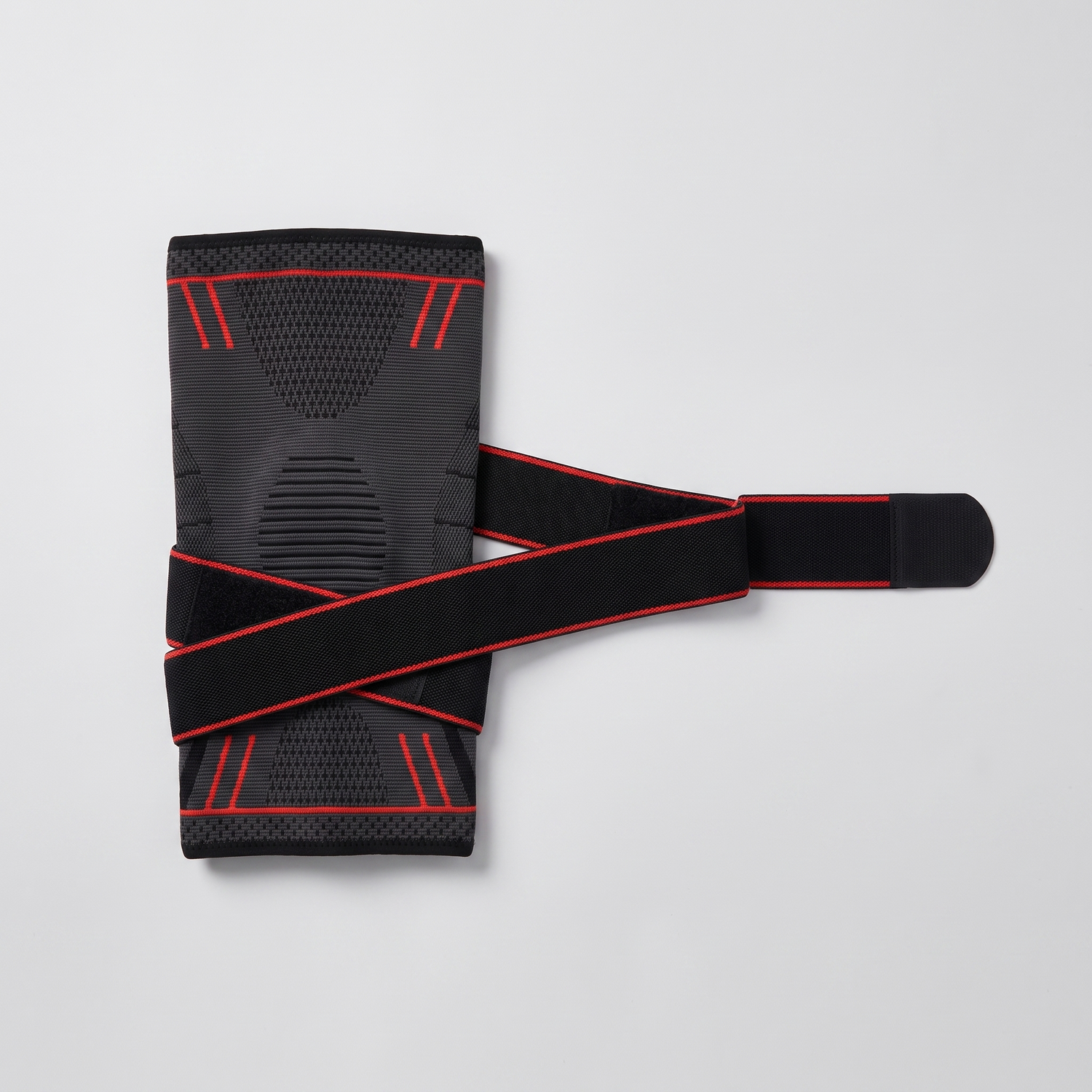Genouillère de compression noir et rouge présentée à plat