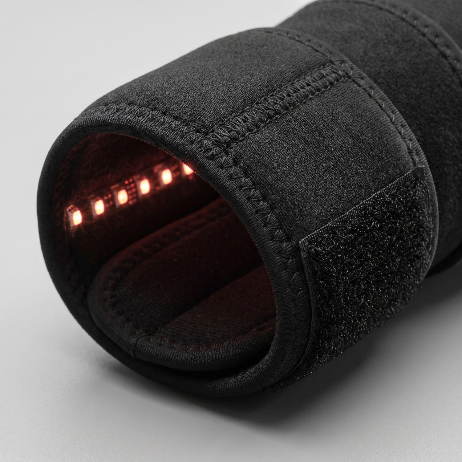 Gros plan sur les LED infrarouge rouges et le néoprène mat de l'attelle chauffante