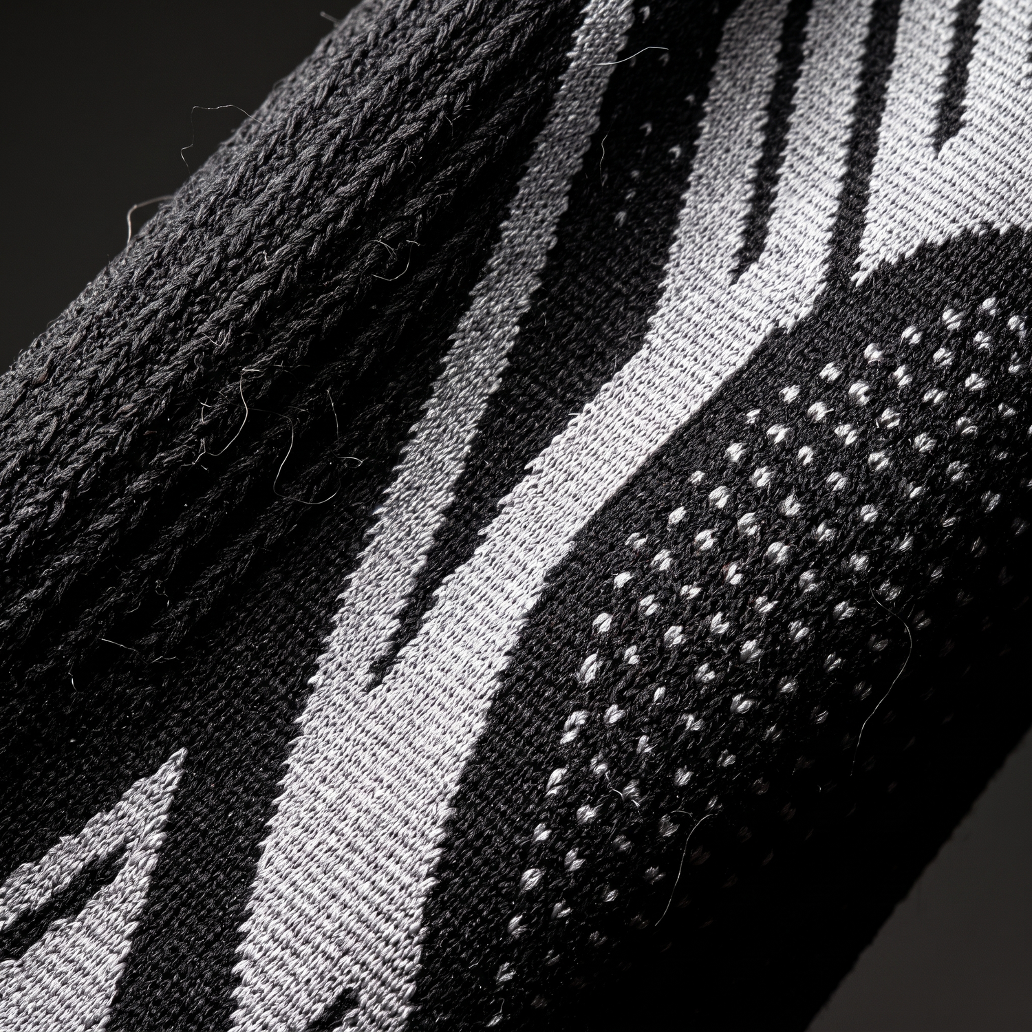 Macro du tricot compressif noir et de la zone rotulienne renforcée à points saillants